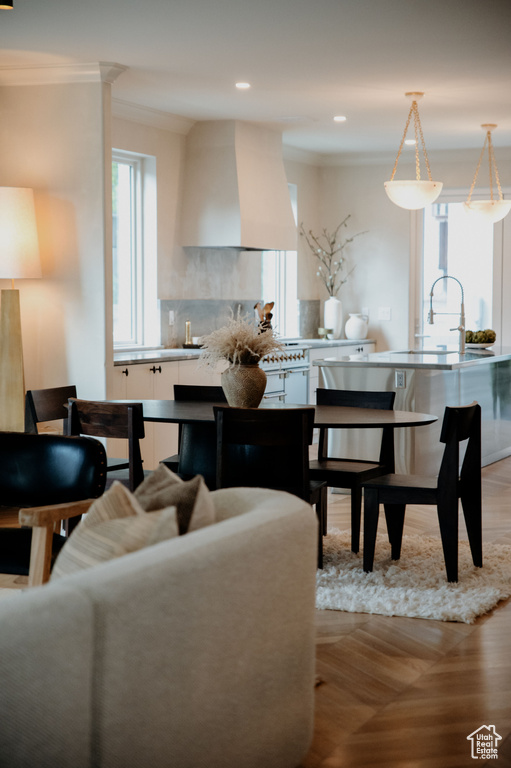Living room with ornamental molding, light wood-style flooring, and recessed lighting