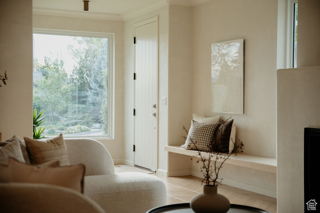 Living area featuring healthy amount of natural light, ornamental molding, and baseboards