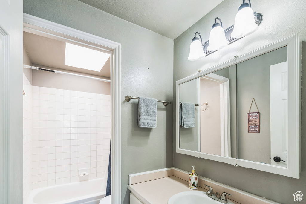 Bathroom with shower / tub combo with curtain, toilet, and vanity