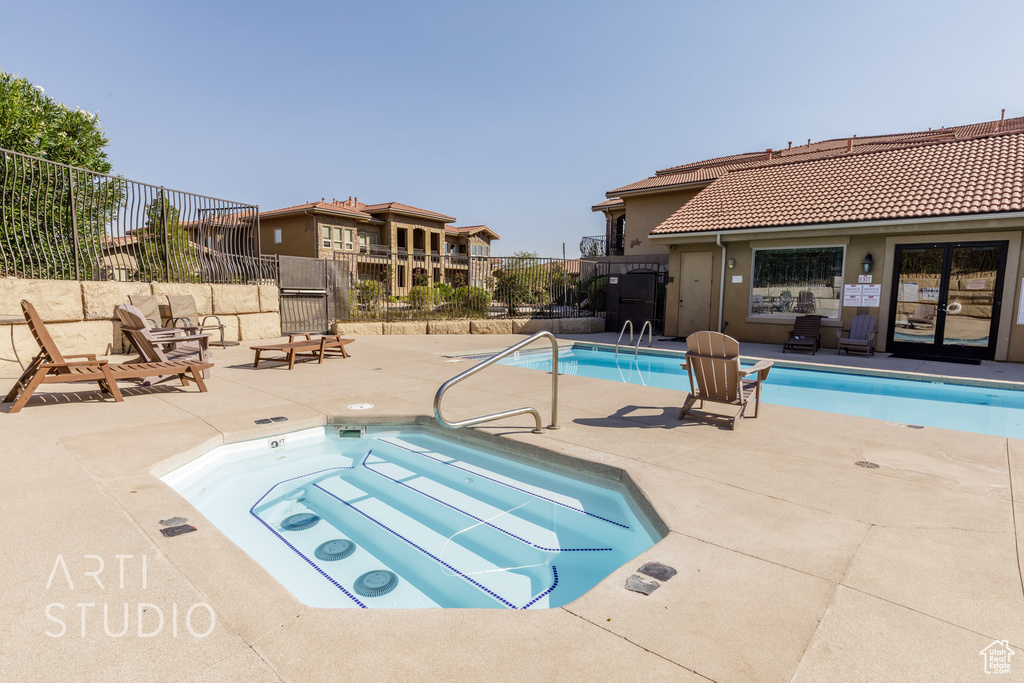 Community pool featuring a community hot tub and a patio