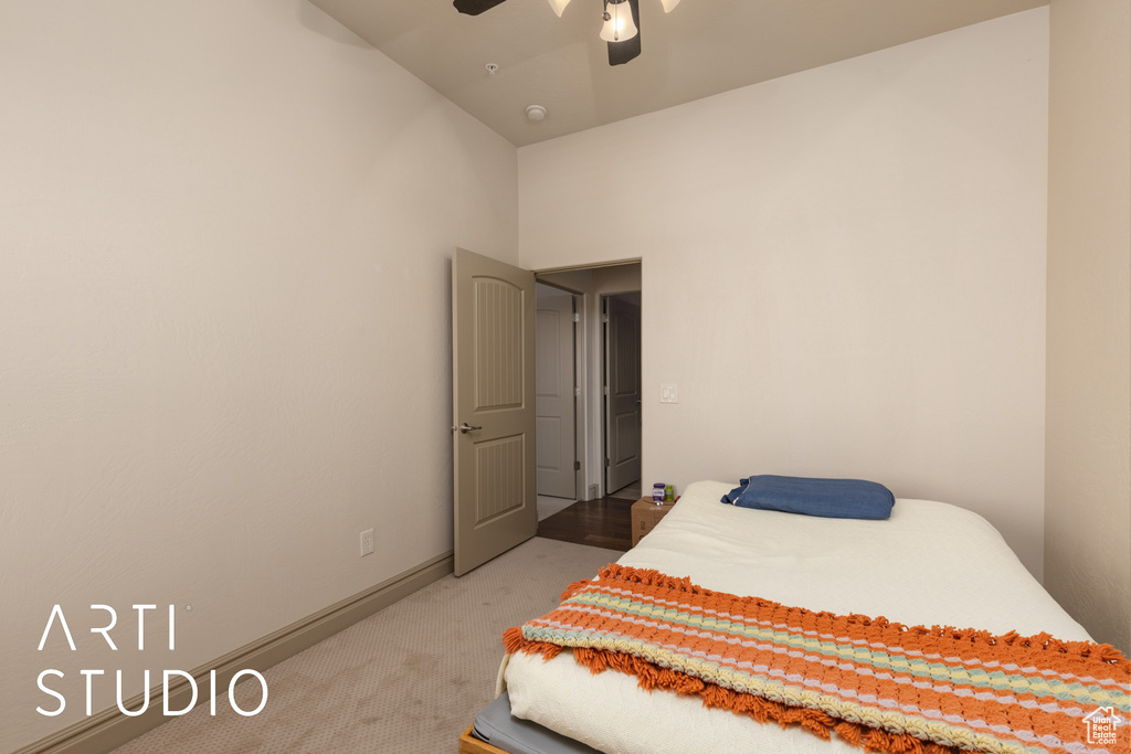 Bedroom with light colored carpet, ceiling fan, baseboards, and a towering ceiling