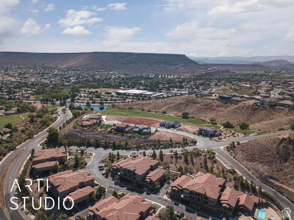 Aerial view of property and surrounding area with nearby suburban area and a water and mountain view