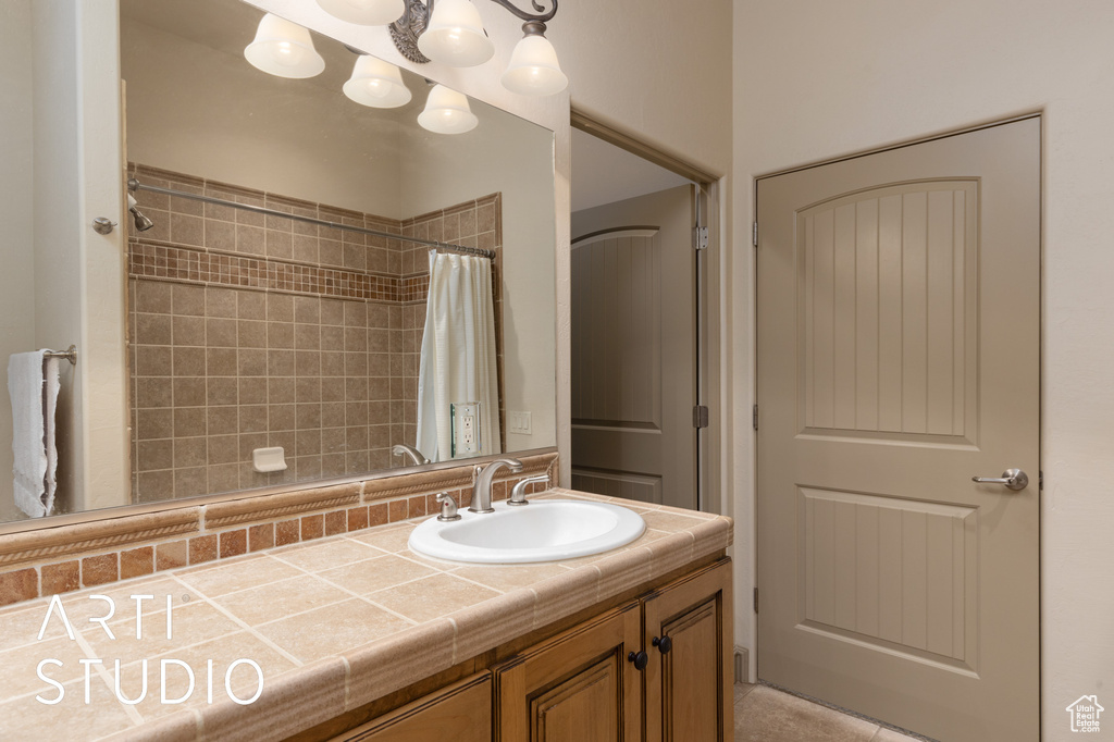 Full bath featuring curtained shower, vanity, and tile patterned floors