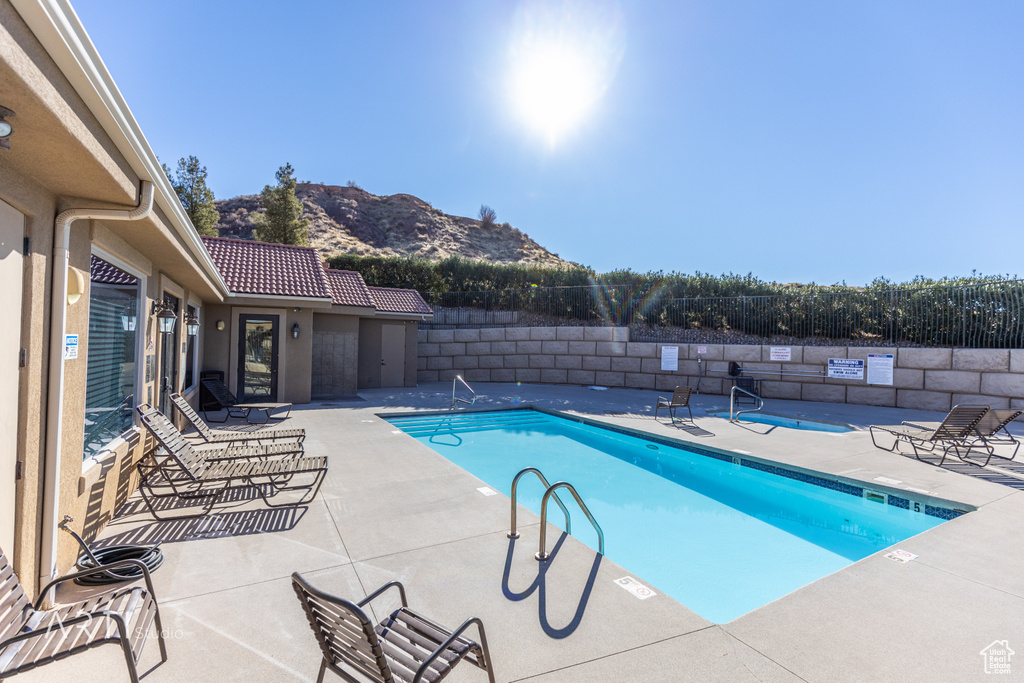 Community pool featuring a mountain view, a fenced backyard, and a patio area
