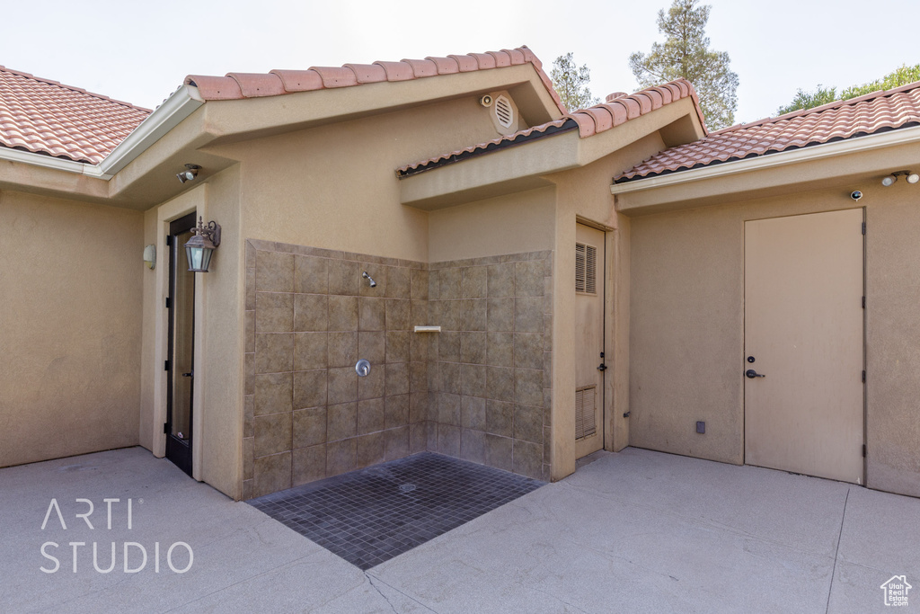 View of exterior entry featuring stucco siding and a tile roof