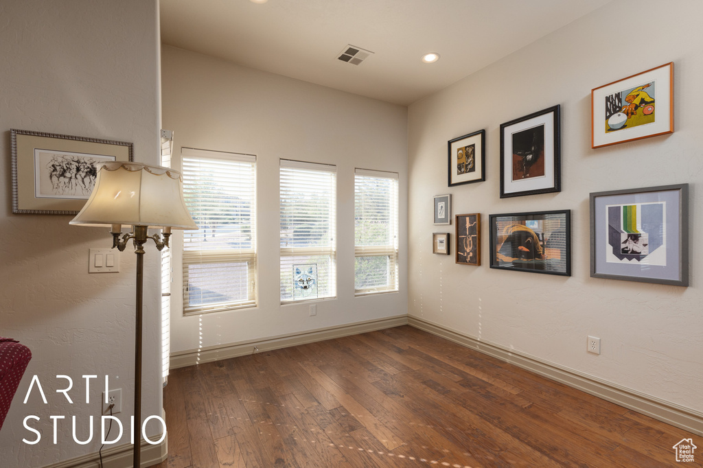Empty room featuring wood-type flooring, baseboards, and recessed lighting
