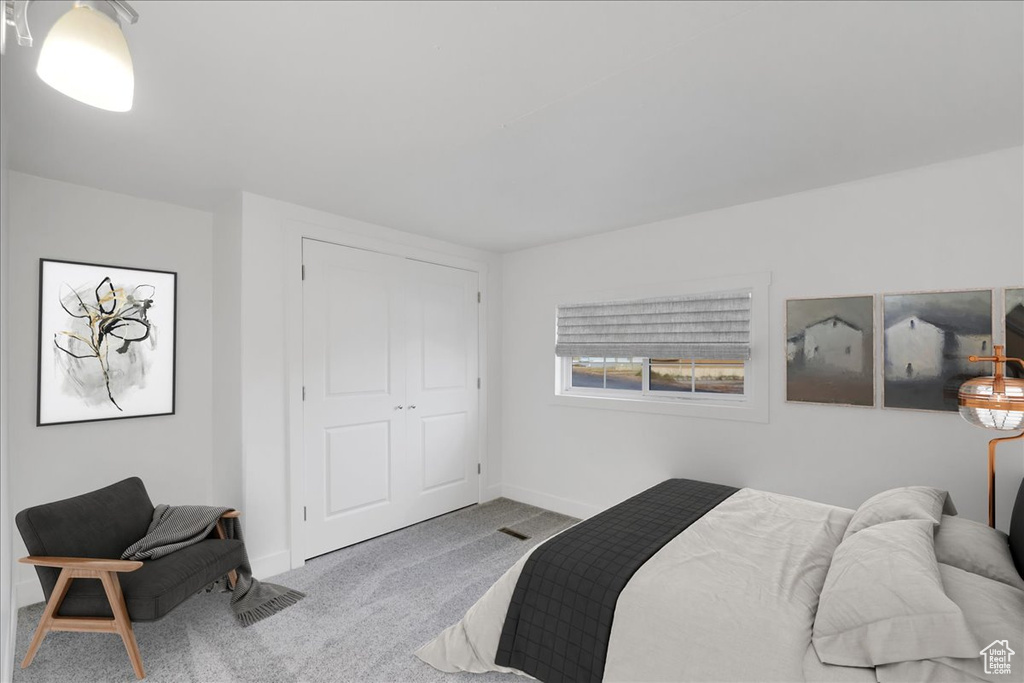 Carpeted bedroom with baseboards and a closet
