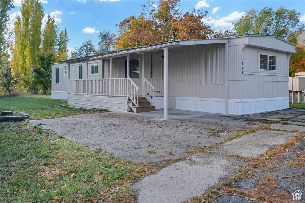 Manufactured / mobile home with a porch and a front lawn