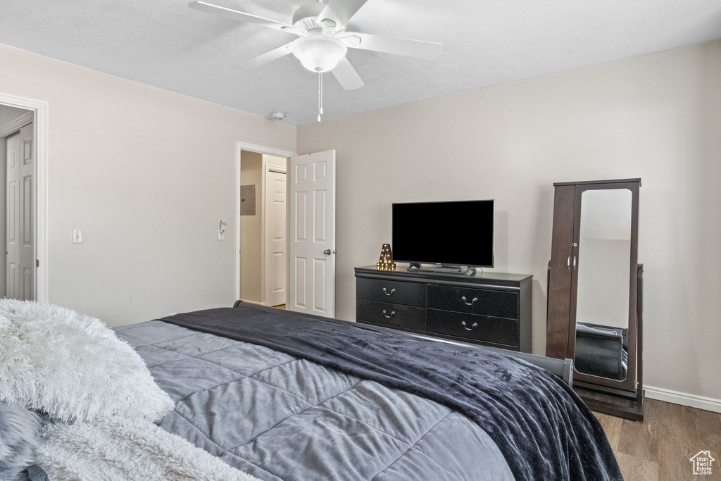 Bedroom featuring wood finished floors, baseboards, and a ceiling fan