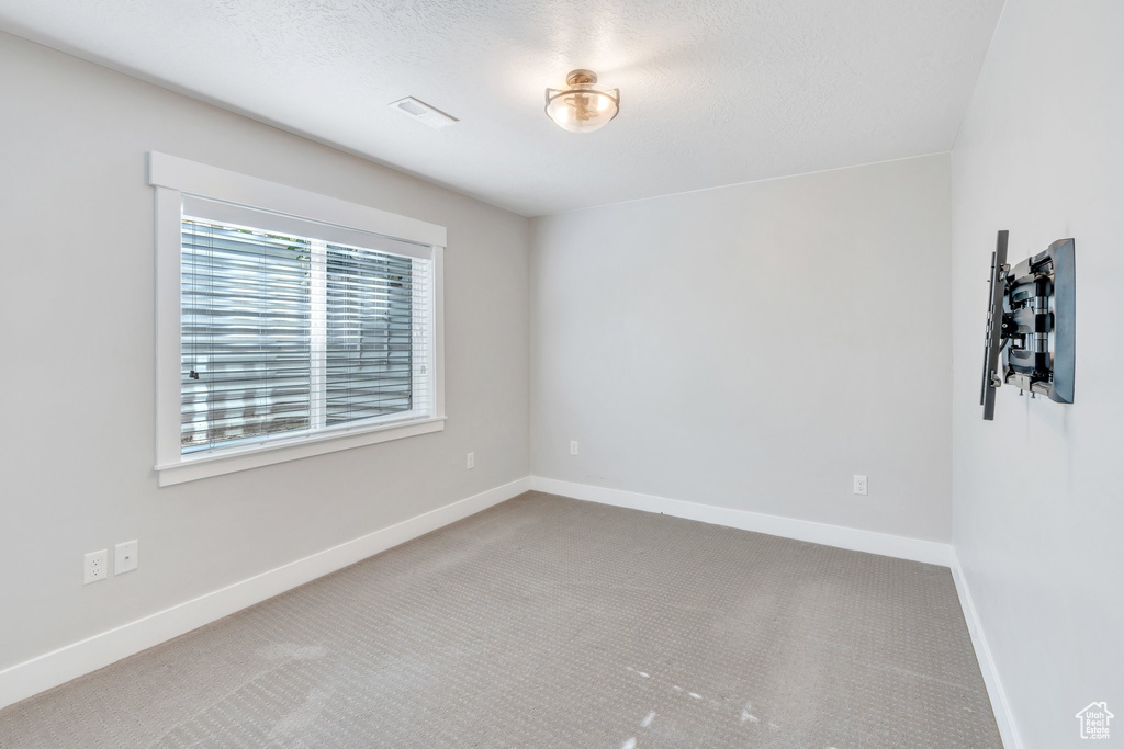 Carpeted empty room featuring baseboards
