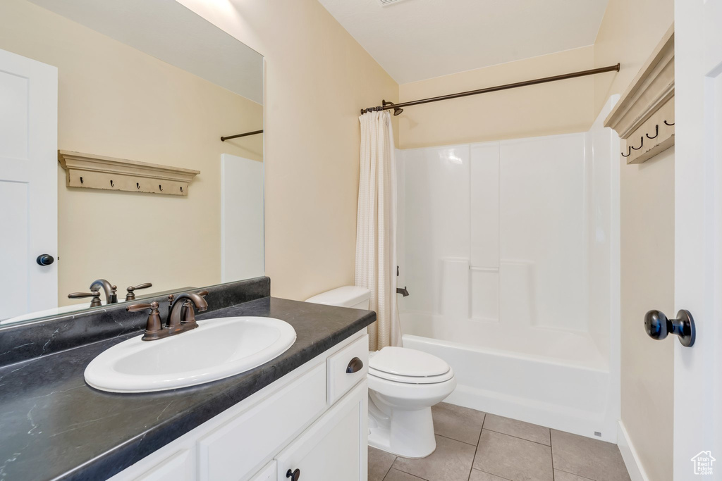 Full bath with toilet, tile patterned floors, shower / bath combo, and vanity