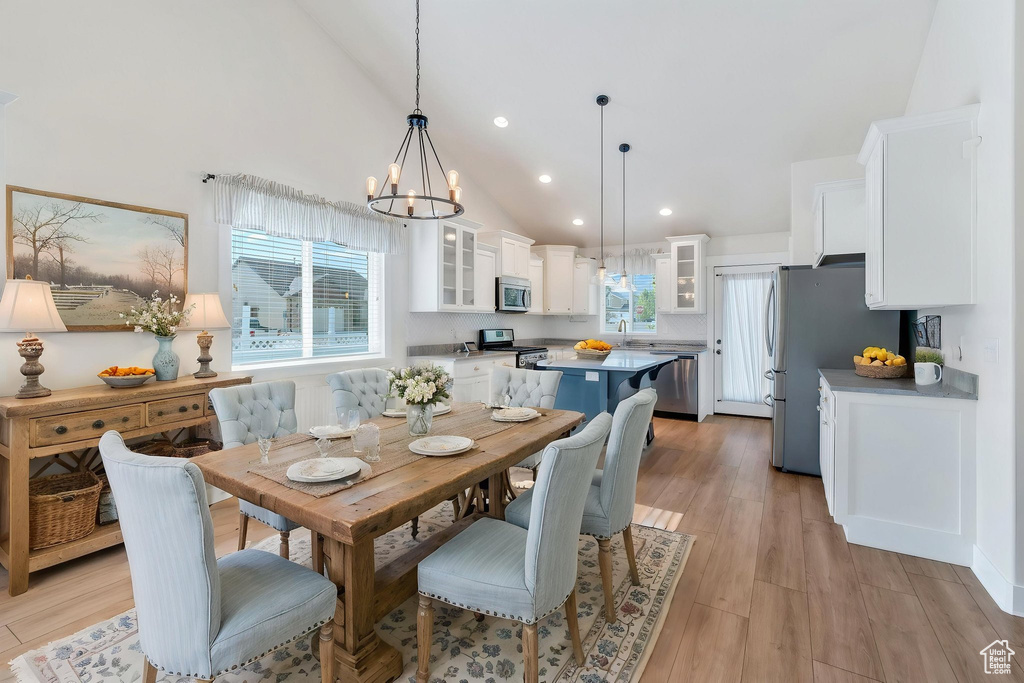 Dining room featuring high vaulted ceiling, a chandelier, recessed lighting, and light wood finished floors