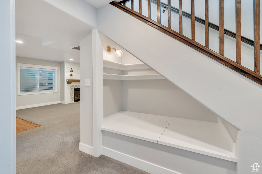 Stairway with carpet, a fireplace, baseboards, and recessed lighting