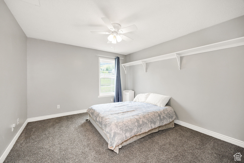Bedroom with carpet, baseboards, and a ceiling fan