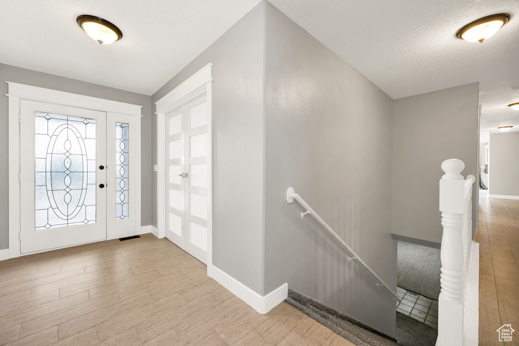 Entryway featuring wood finished floors, baseboards, and a textured ceiling