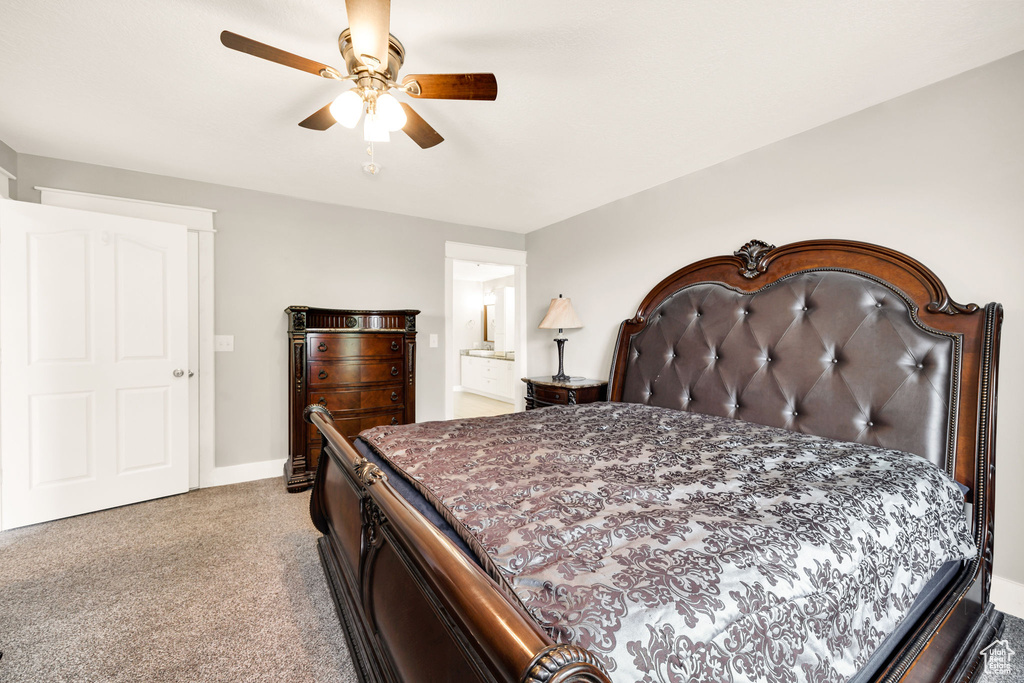 Bedroom with light carpet, baseboards, a ceiling fan, and ensuite bathroom