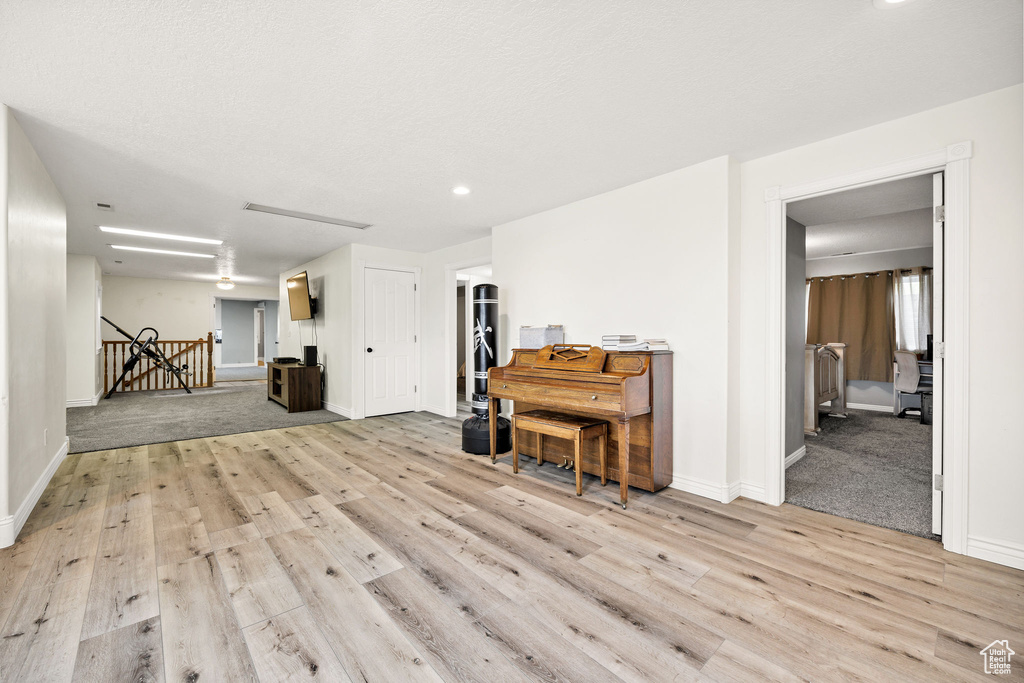 Living area with light wood-type flooring, baseboards, and recessed lighting