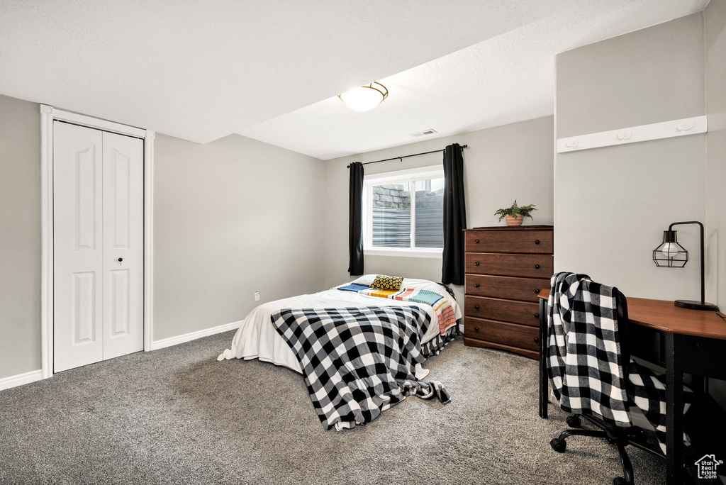Carpeted bedroom with a closet and baseboards