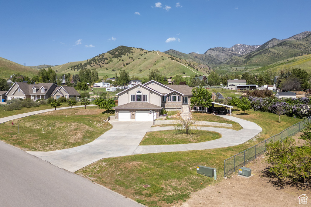 View of front of house with concrete driveway, a garage, and a mountain view