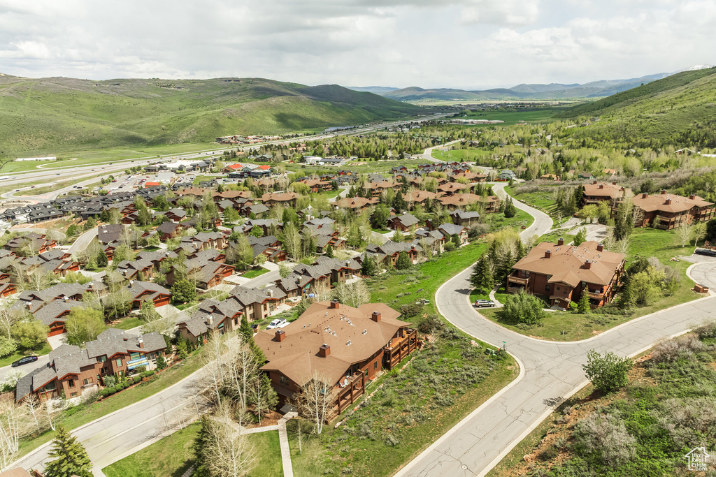 Aerial view of property's location with nearby suburban area and a mountainous background