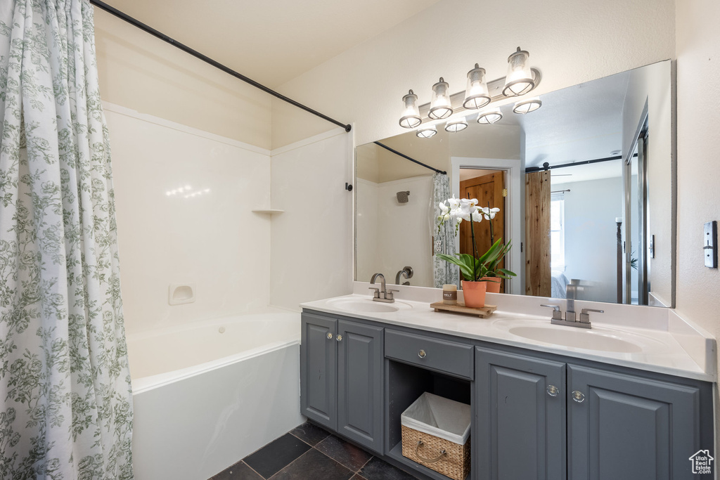 Bathroom with shower / tub combo with curtain and double vanity