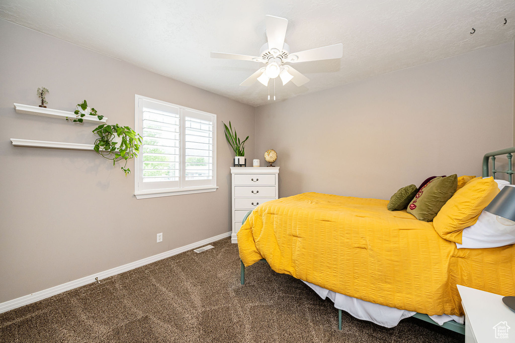 Carpeted bedroom with baseboards and a ceiling fan