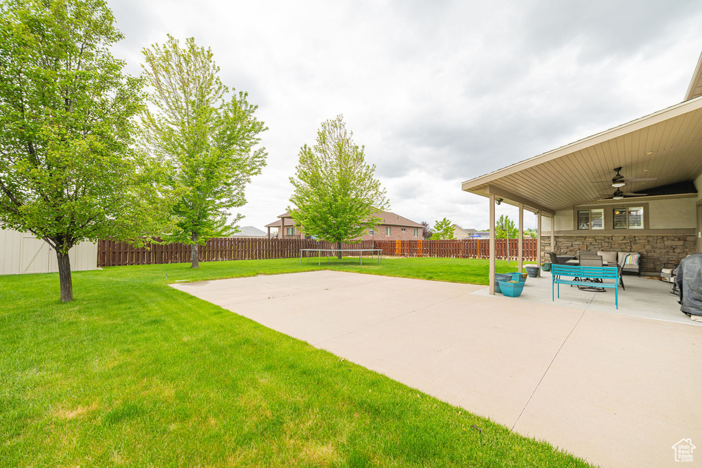 View of yard featuring a ceiling fan, a patio, a trampoline, and outdoor lounge area