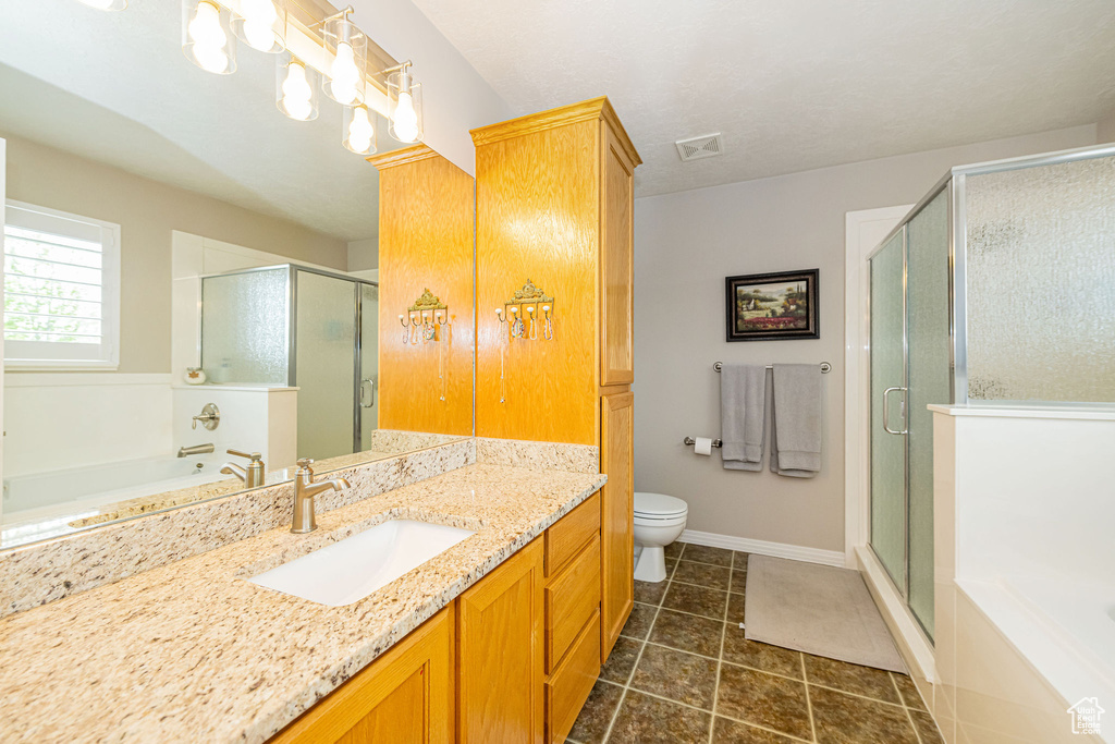 Bathroom featuring vanity, a shower stall, tile patterned flooring, and a garden tub