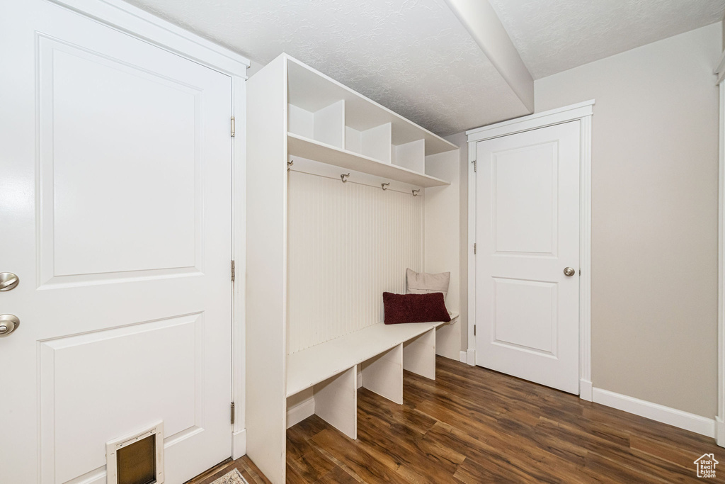 Mudroom with dark wood-style flooring, baseboards, and a textured ceiling