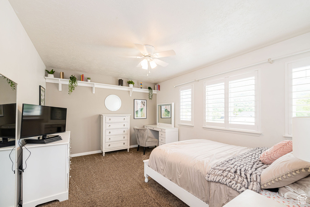 Bedroom featuring carpet floors, baseboards, and a ceiling fan