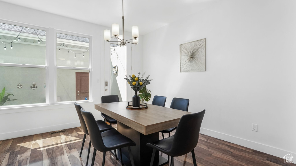 Dining room with baseboards, a chandelier, and dark wood-style floors