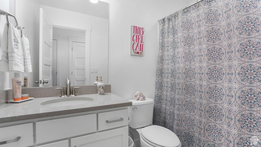 Full bathroom with vanity, toilet, and a shower with shower curtain