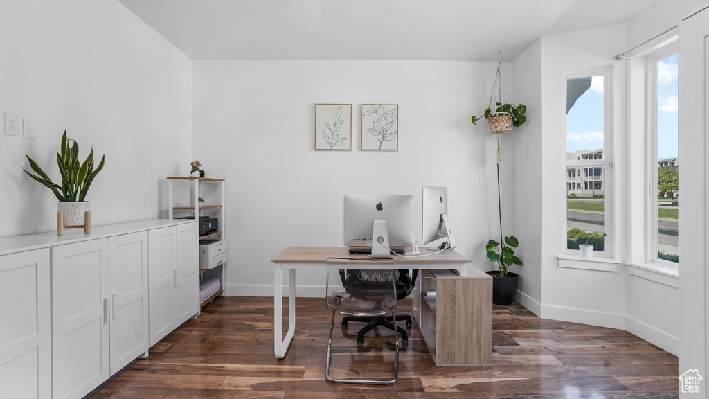 Office space featuring baseboards and dark wood-type flooring