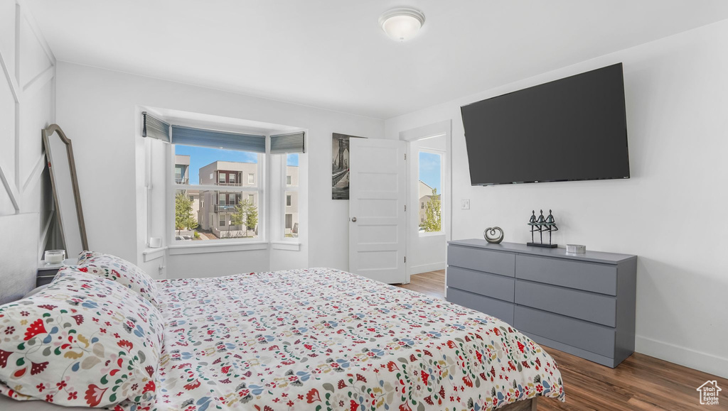 Bedroom with wood finished floors and baseboards