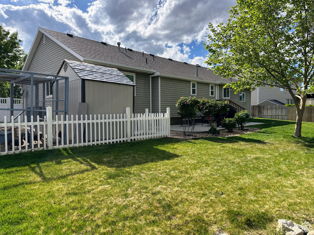 Rear view of property with a patio and roof with shingles