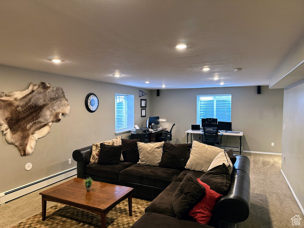 Living area featuring baseboard heating, light colored carpet, a desk, recessed lighting, and baseboards