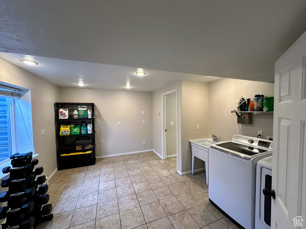 Laundry area with independent washer and dryer, baseboards, and light tile patterned floors