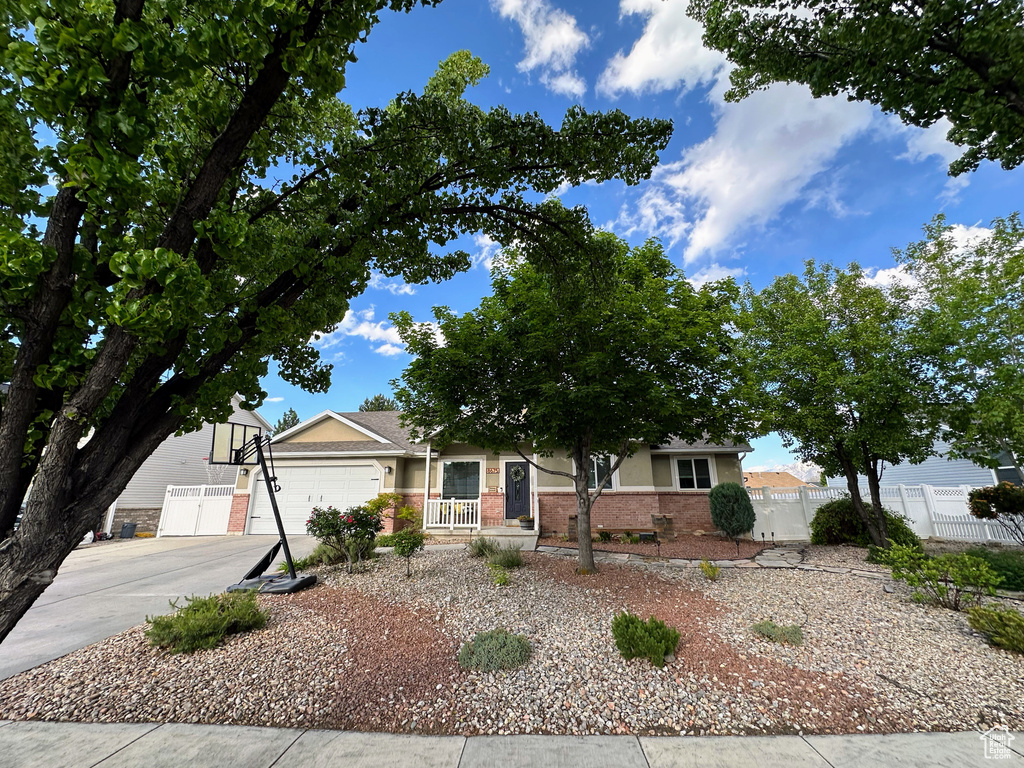 View of front of home with brick siding, driveway, and an attached garage