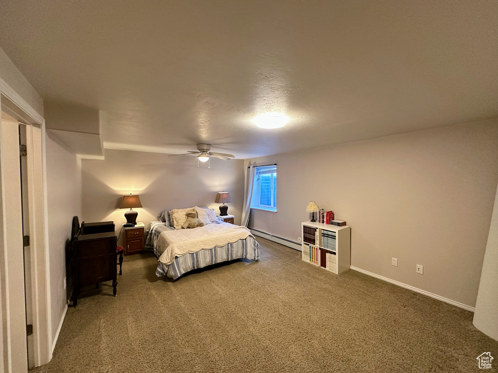 Bedroom featuring baseboard heating, carpet, baseboards, and a ceiling fan