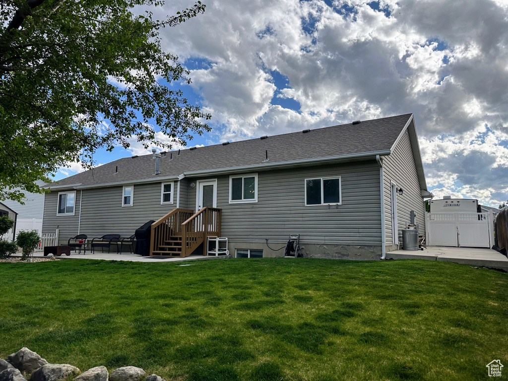 Back of house featuring a patio area, central air condition unit, and roof with shingles