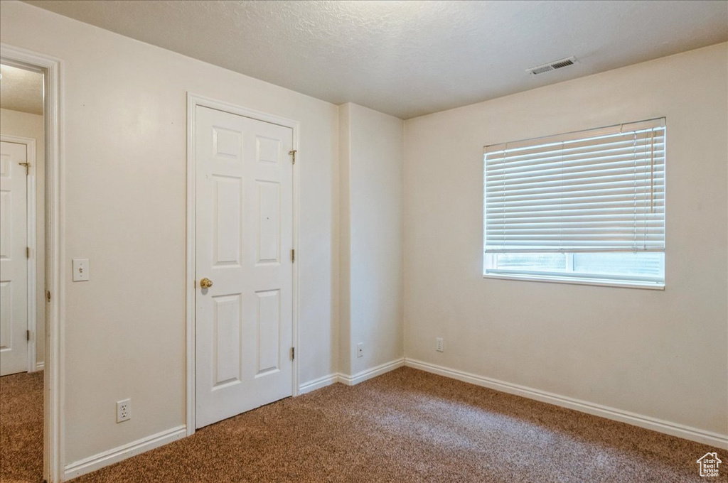 Unfurnished bedroom with carpet and baseboards