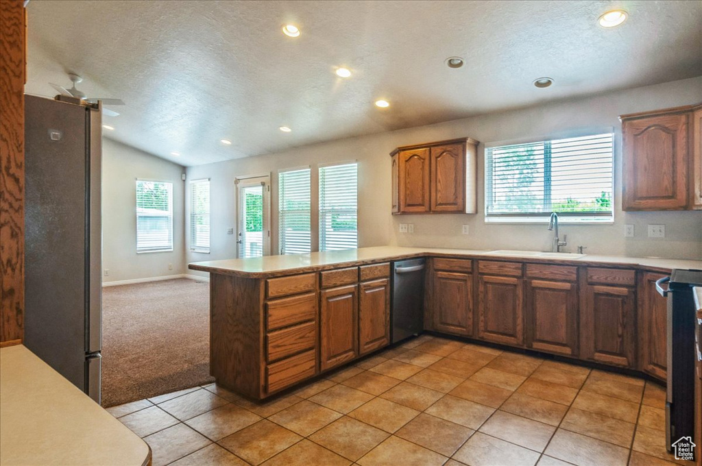 Kitchen featuring a sink, stainless steel appliances, recessed lighting, a textured ceiling, and a peninsula