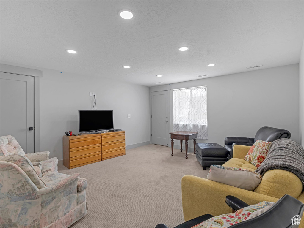 Living area with recessed lighting, light carpet, and baseboards
