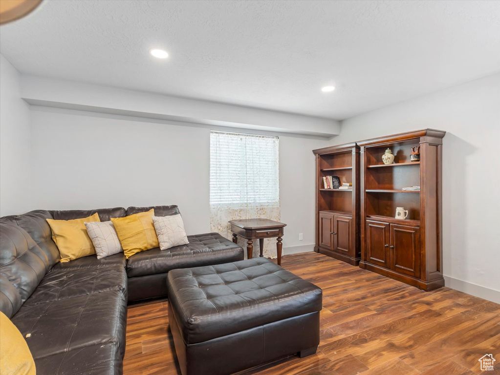 Living area with dark wood-style floors, baseboards, and recessed lighting