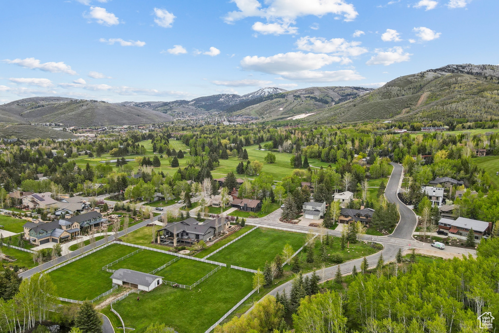 Aerial view of property and surrounding area with mountains and nearby suburban area