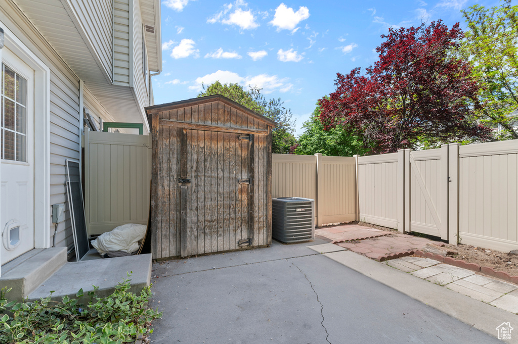 Fenced backyard with a patio area, a gate, and central AC unit
