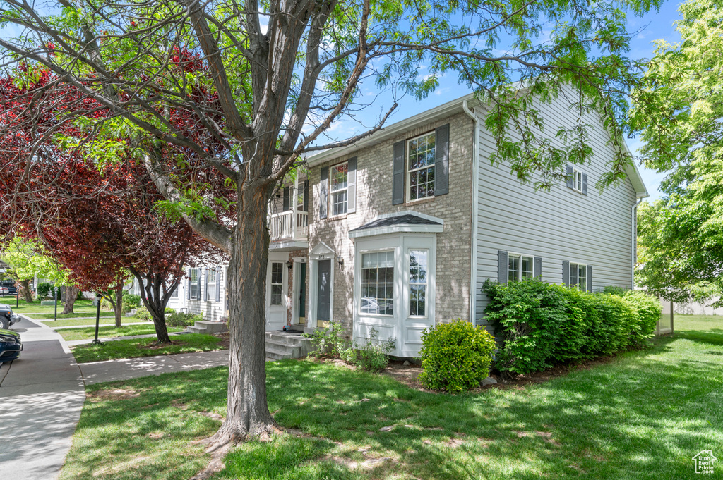View of front of home featuring a front lawn and a balcony