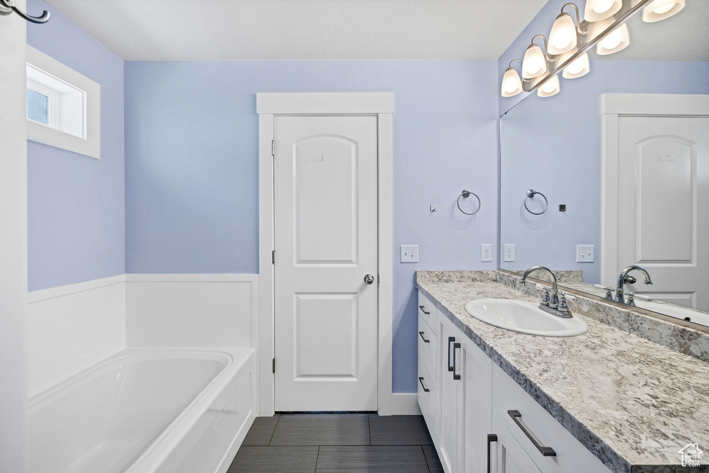 Full bathroom featuring vanity, a bath, and tile patterned flooring