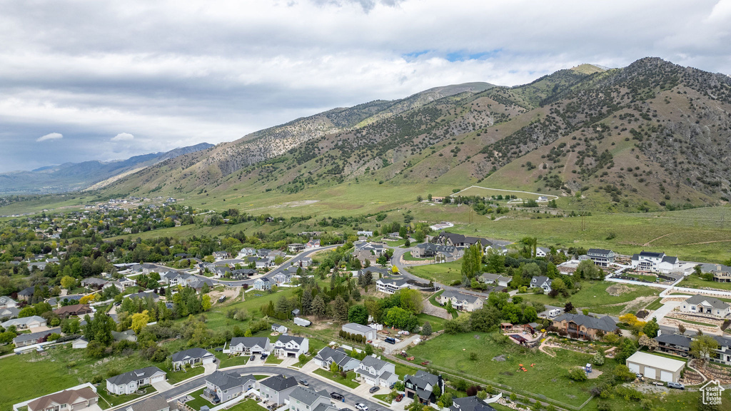 Aerial view of property and surrounding area featuring nearby suburban area and mountains