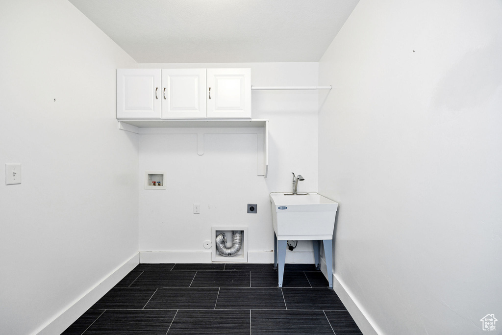 Washroom with cabinet space, electric dryer hookup, hookup for a washing machine, baseboards, and wood finish floors
